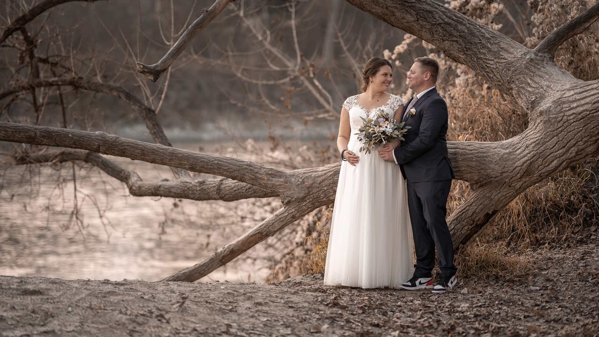 Hochzeitspaar vor altem Baum Flussufer